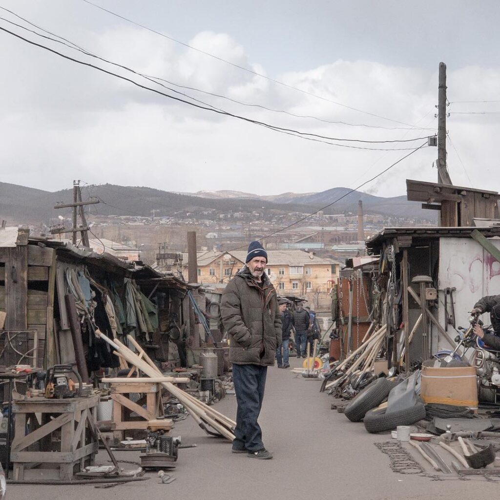 un uomo tra delle case in rovina in una città in Russia, fotografia di Dmitry Markov
